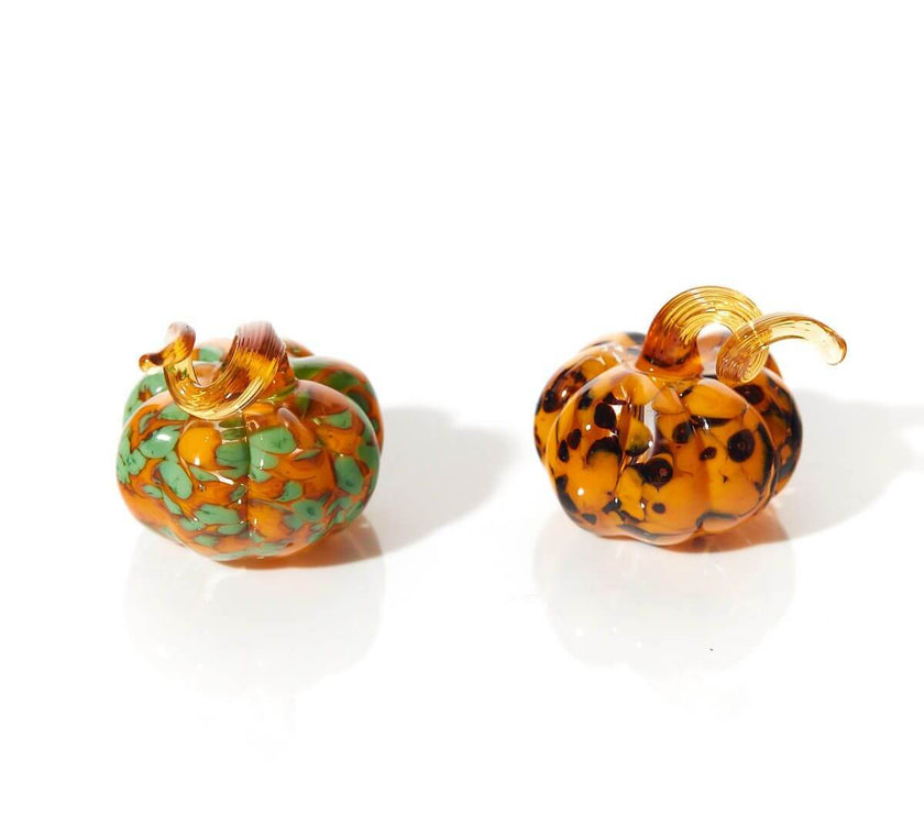 Halloween glass pumpkin ornaments with assorted swirl patterns, perfect for adding elegance to festive décor displays.