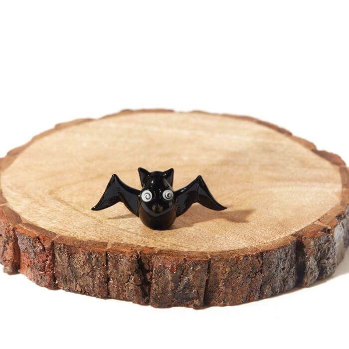 Black Halloween glass bat ornament with googly eyes on natural wood slice, perfect for spooky fun décor or gifting